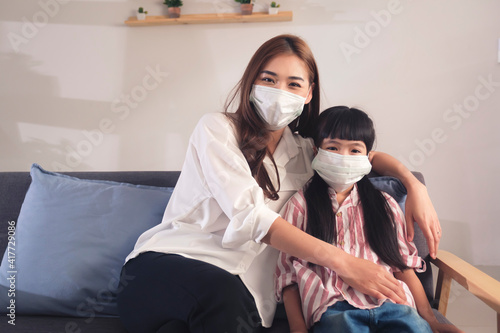 Asian family parent mother wearing protective surgical facemask with daughter work from home and online class study education  safety prevention from coronavirus covid19 pandemic quarantine  women day