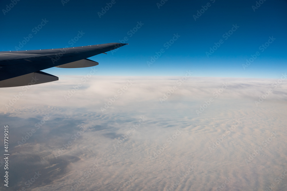 Aerial View from an Airplane. Flying above Clouds at Sunrise Aerial View from an Airplane. Flying above Clouds at Sunrise