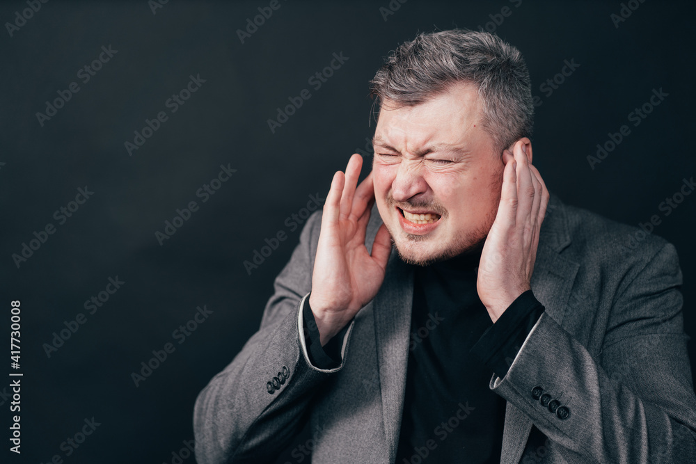 Man touching his temples suffering from headache, feeling stress. Migraine, fatigue, annoying concept Man touching his temples suffering from headache, feeling stress. Migraine, fatigue, annoying concept