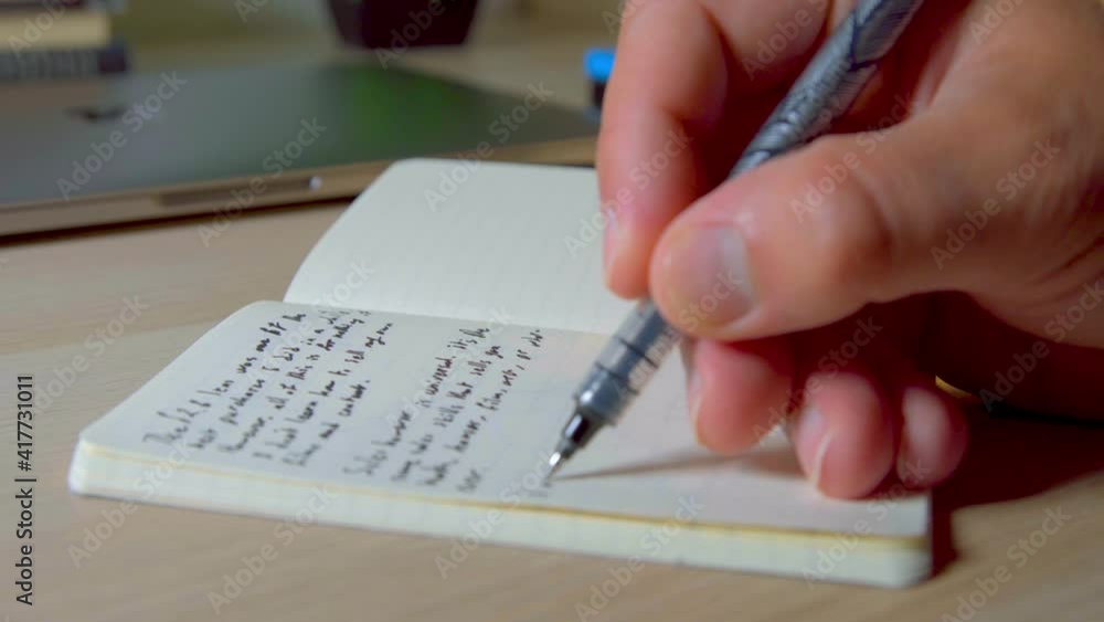Taking handwritten notes in small notebook, closing pen lid Taking handwritten notes in small notebook, closing pen lid