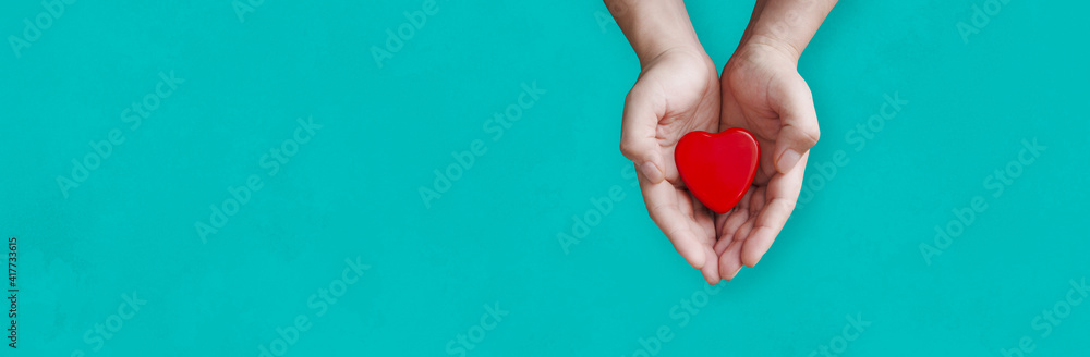 person holding a heart in his hands with blue background
