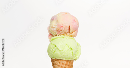 Rainbow on top Ice cream lime scoop in waffle cone on white background, Closeup Front view Food concept.