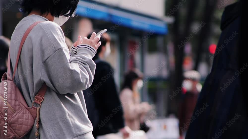 外でスマホを操作する人 外でスマホを操作する人
