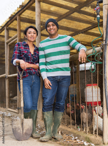 Portrait of two successful farm workers next to the chicken coop