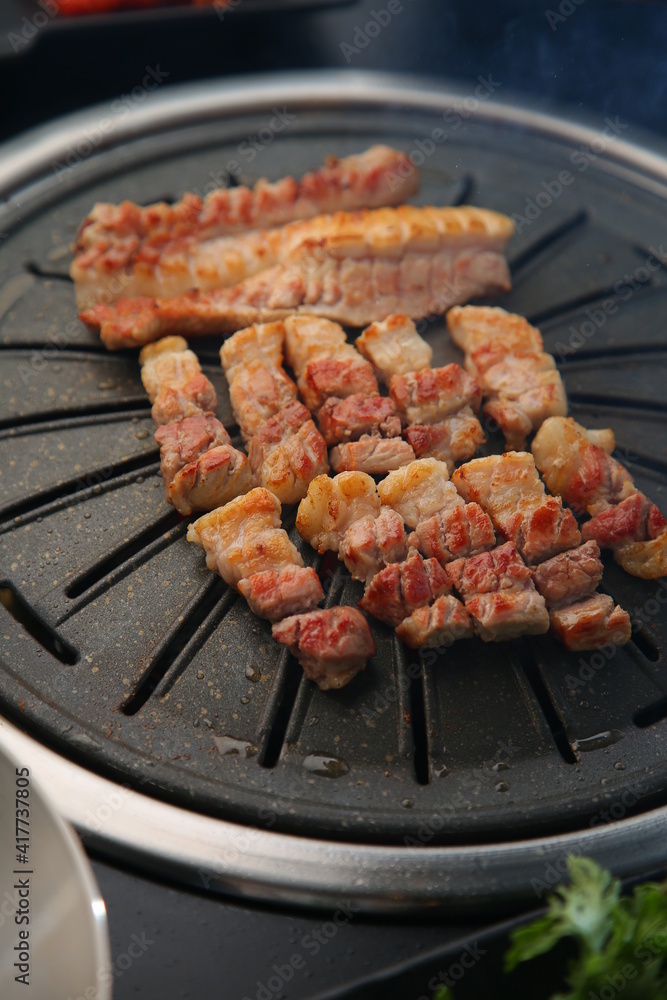 Grilled pork on an iron plate. 철판위에서 노릇노릇 익어가고 있는 돼지고기