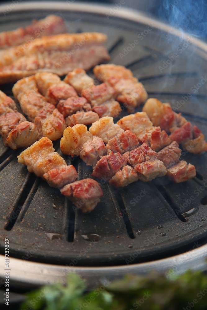 Grilled pork on an iron plate. 철판위에서 노릇노릇 익어가고 있는 돼지고기 Grilled pork on an iron plate. 철판위에서 노릇노릇 익어가고 있는 돼지고기