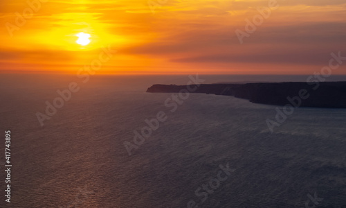 The sun setting into the sea and the long cape crashing into the Black Sea at sunset. Coast of the Crimean Peninsula near Balaklava.