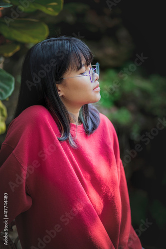 portrait of asian teenager wearing eyeglasses standing outdoor