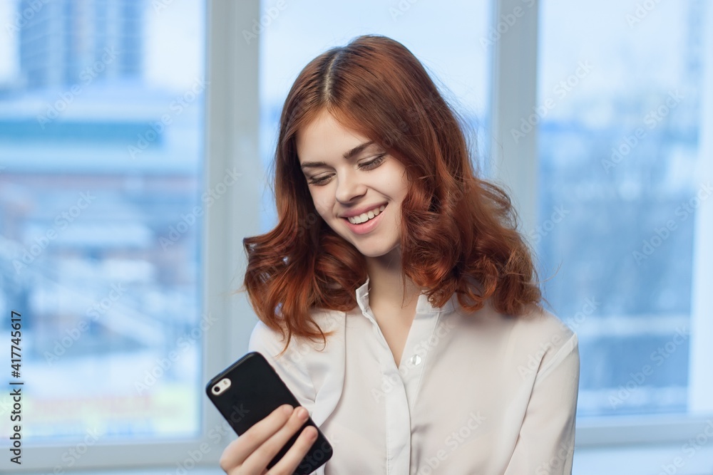woman in shirt with phone in hand technology professional woman in shirt with phone in hand technology professional