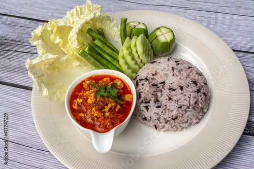 Nam phrik ong is a popular Thai food in Northern Thailand. Composition with rice, pork and fresh vegetables as cucumber, Chinese cabbage, cow pea, eggplant.  photo