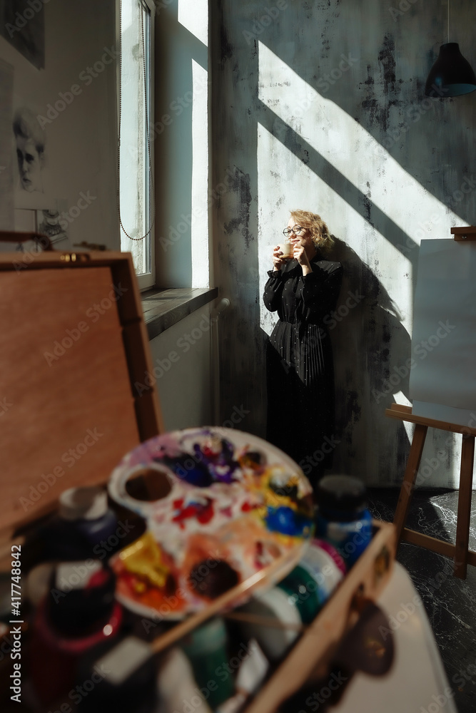 © Danila Shtantsov - Vertical portrait of a young woman standing near the window with cup of coffee © Danila Shtantsov - Vertical portrait of a young woman standing near the window with cup of coffee