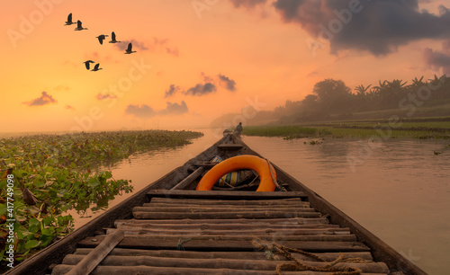 Scenic river sunset with rural landscape as viewed from a fishing boat. Photograph shot at Burdwan district in West Bengal, India photo