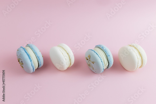 White and blue macaroons on the table, macaroons on pink background