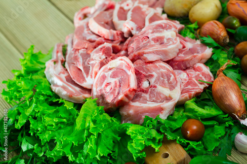 Raw lamb and vegetables assortment on natural wooden desk, cooking ingredients