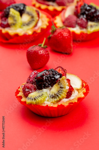 Tartles with fruits and berries on red background