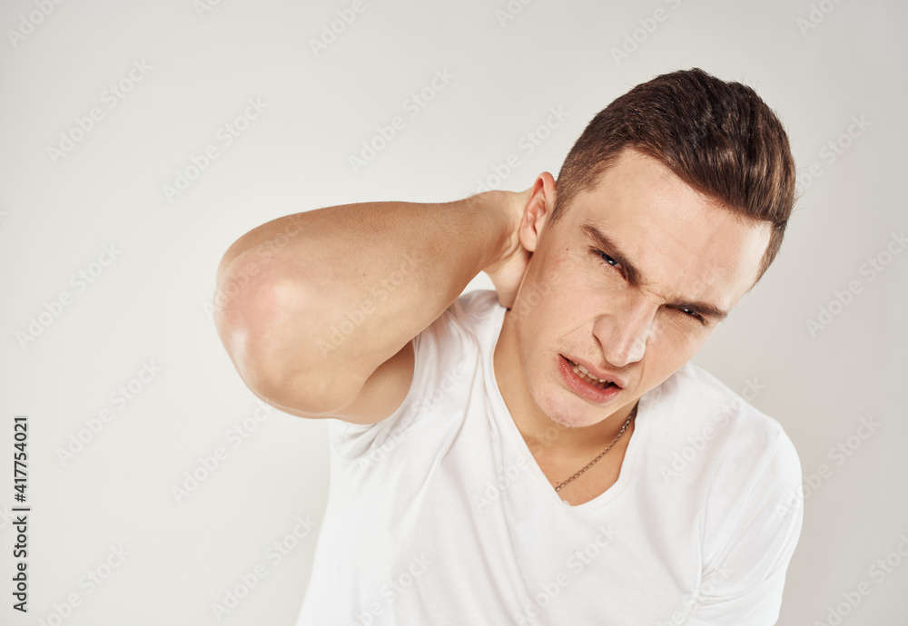 Nice guy in a white T-shirt on a light background cropped view portrait close-up Nice guy in a white T-shirt on a light background cropped view portrait close-up