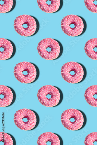 pattern with pink donuts on a blue background. flat view with donuts vertical photo