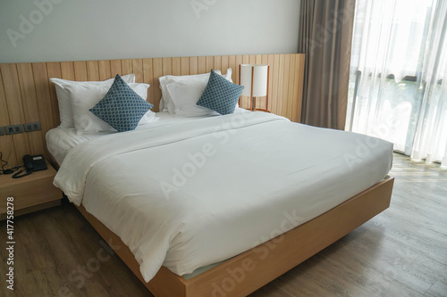 minimal double bed with white mattress in luxury hotel bedroom