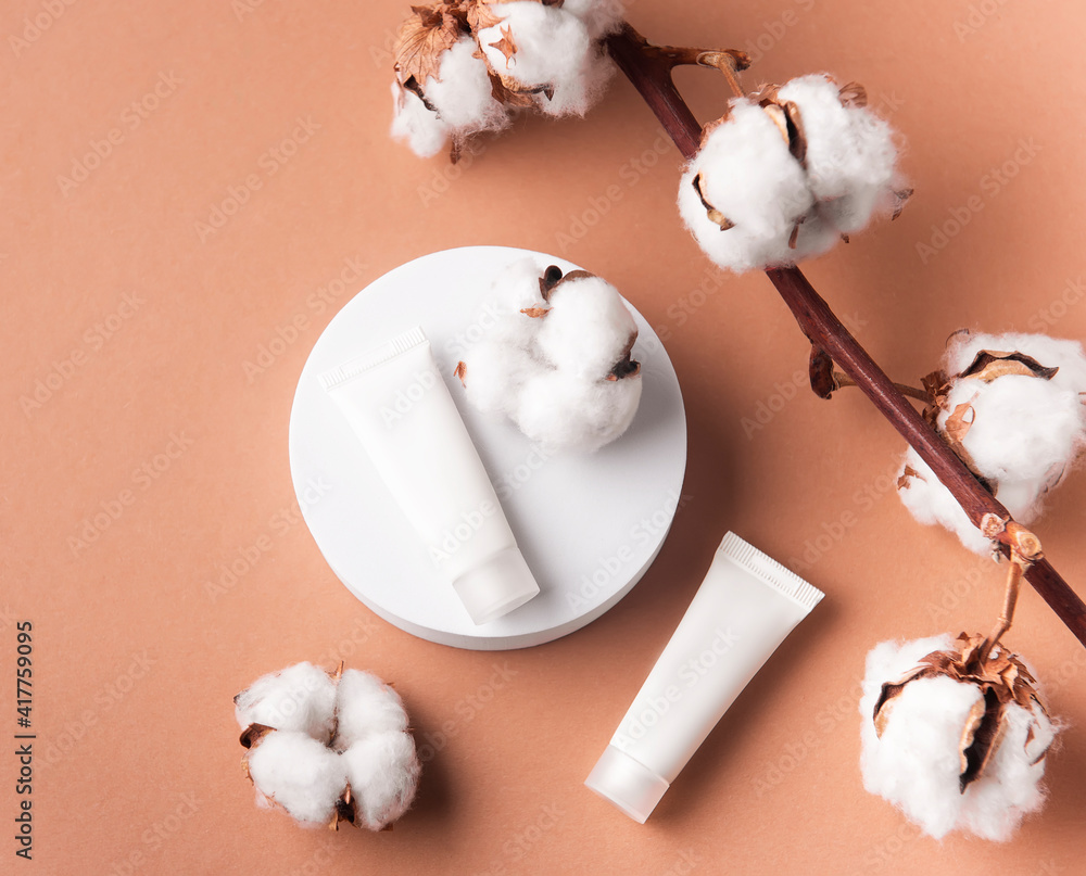 White tubes of cream on a brown background White tubes of cream on a brown background