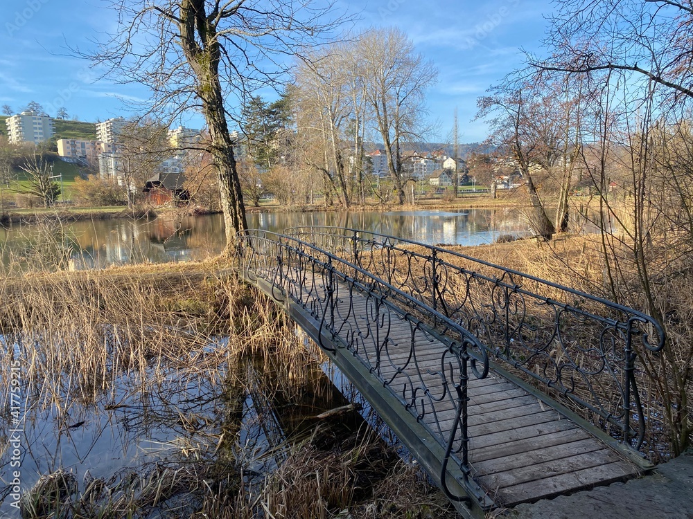 A small pedestrian bridge next to Au Castle with the surrounding park ...
