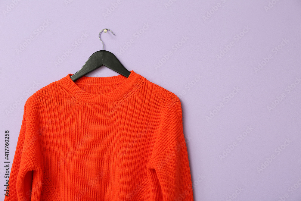 Hanger with stylish sweater on color background Hanger with stylish sweater on color background