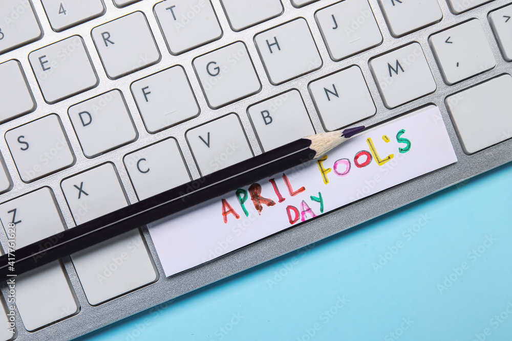 Computer keyboard with pencil and text APRIL FOOL'S Day on color background Computer keyboard with pencil and text APRIL FOOL'S Day on color background