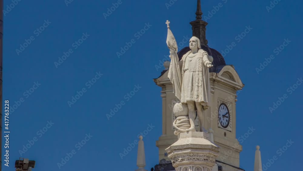 Monument to explorer Christopher Columbus (Cristobal Colon) and tower with watch timelapse hyperlapse on the Columbus square (plaza de Colon). Torres de Colon is a high office building of twin towers Monument to explorer Christopher Columbus (Cristobal Colon) and tower with watch timelapse hyperlapse on the Columbus square (plaza de Colon). Torres de Colon is a high office building of twin towers