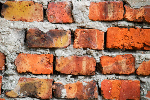 Vintage brick wall. Red bricks are textured. View from the front.