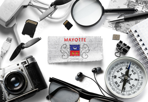 Flag of Mayotte and travel accessories on a white background. photo