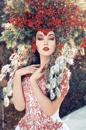 Valokuva fantasy winter queen standing in the forest in falling snow, a beautiful woman i