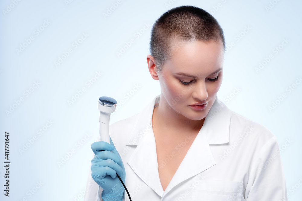 Portrait of a woman dermatologist holding cosmetic device attachment Portrait of a woman dermatologist holding cosmetic device attachment