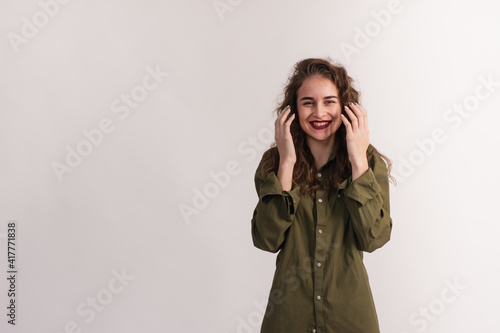 A surprised, smiling girl holds her hands near her face. The young woman is happy and does not believe that this happened. isolated on a white background. copy space