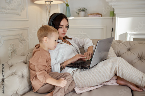 Mom daughter and son play on laptop. Family recreation and leisure © angel_nt