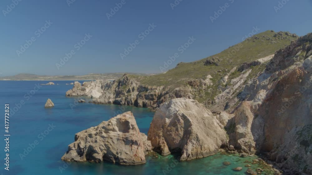 Cliffs and Rocks Cascading into the Aegean Blue Sea in Milos Greece Cliffs and Rocks Cascading into the Aegean Blue Sea in Milos Greece