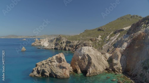 Cliffs and Rocks Cascading into the Aegean Blue Sea in Milos Greece photo