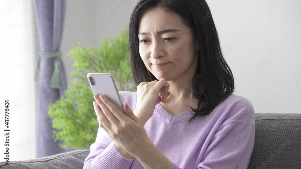 スマートフォンを見るミドル女性