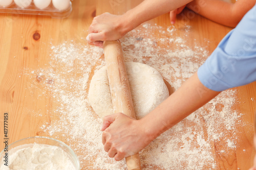 Close up of woman with her child kneading dough
