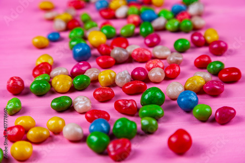 Multicolored candies on a pink background.