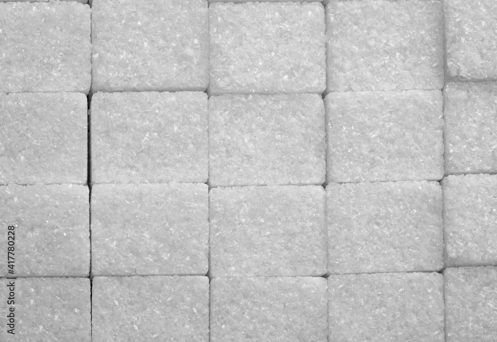 Naklejka premium White sugar cubes arranged at the background