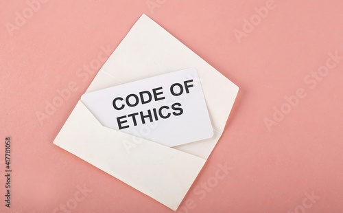 Word Writing Text CODE OF ETHICS on card on the pink background