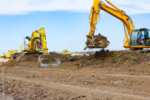 Two big excavators are leveling ground on building site