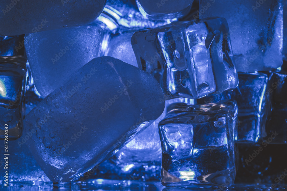 Fototapeta Closeup shot of ice cubes under blue light