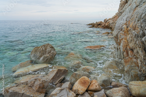 Closeup shot of waves washing the rocky coast of Sansone beach, Island of Elba photo