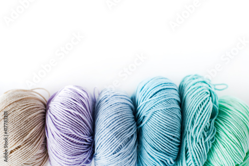  Women's hobby. Crochet and knitting.  Multicolored skeins of yarn on a white background. Studio shooting.
