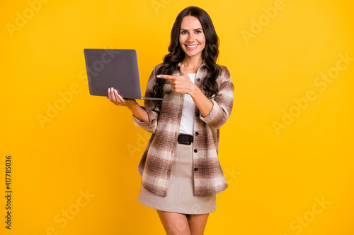 Foto Photo portrait of business woman pointing finger advising laptop isolated on bri