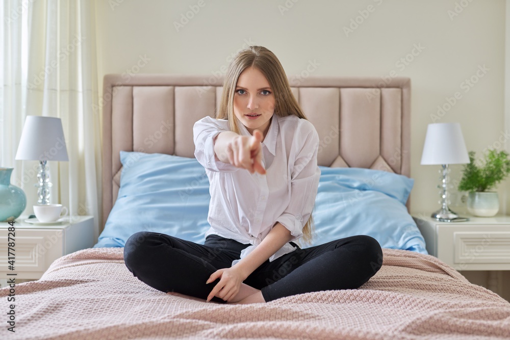 Confident smiling young beautiful woman showing index finger with hand gesture at you Confident smiling young beautiful woman showing index finger with hand gesture at you