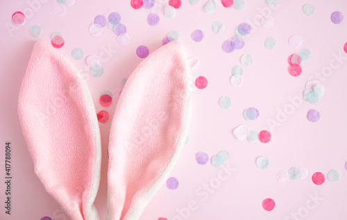 Easter greeting card .Pink bunny ears on pink pastel background wint confetti with, copy spase . Easter minimal concept. Flat lay. advertising concept .