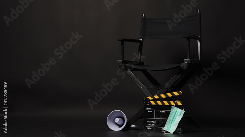 Black Director chair with face mask and Clapperboard or movie slate use in video production or movie and cinema industry. It's black color.