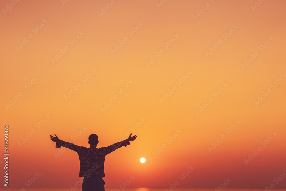 Copy space of man rise hand up on sunset sky at beach and island background.