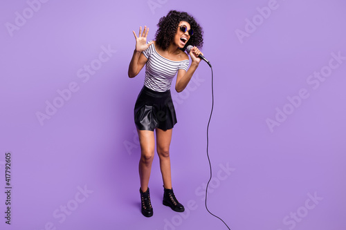 Full size photo of crazy dark skin lady open mouth singing loud have fun isolated on violet color background